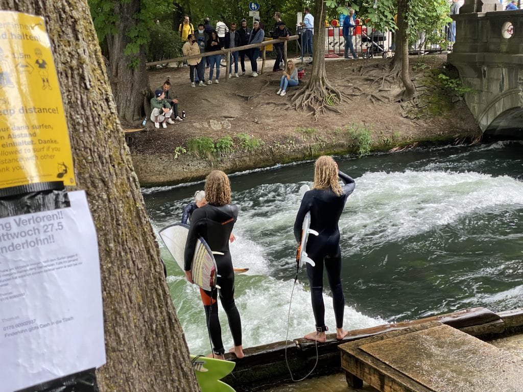 Surfen in München: Zwei Surfer warten darauf, dass sie an der Reihe sind